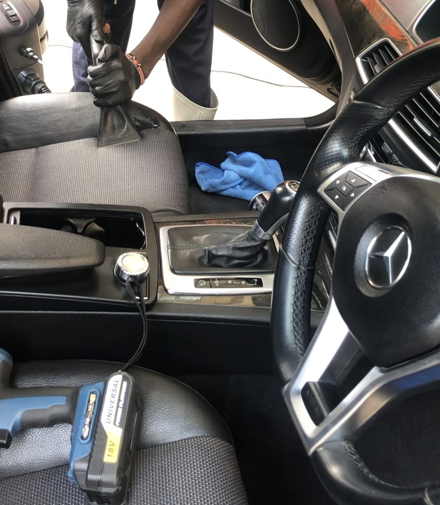 Detailer extracting dirt from a Mercedes seat